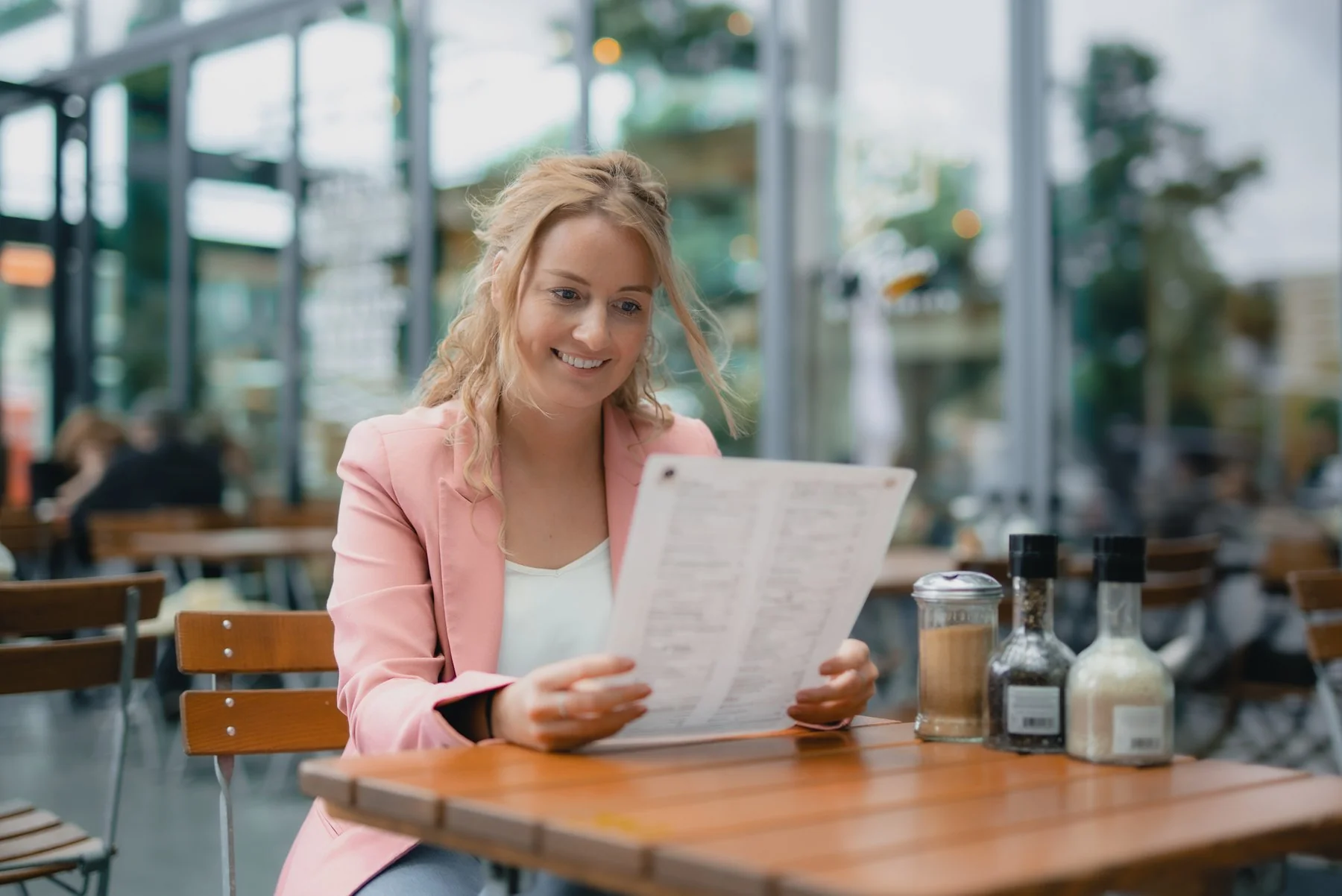 Customer reading a menu at an outdoor café table
